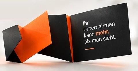 Die Falte entfaltet sich zur Karte mit dem Satz „Ihr Unternehmen kann mehr, als man sieht.“
